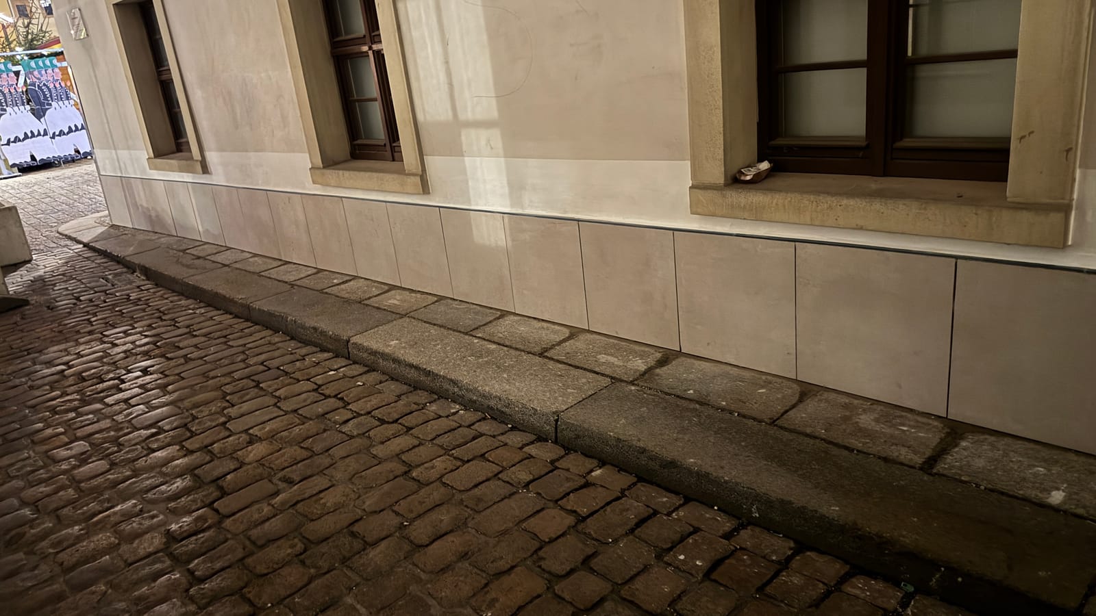 Neu verputzter, gleichmäßiger Gebäudesockel nach der Sanierung